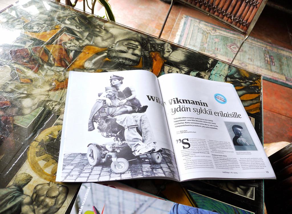 Tom Housen terassipöydällä on avoimena Tukilinja-lehti Wikistä kirjoittamani jutun kohdalla. Pöydän lasilevyn alla on paljon Laaksosen piirtämiä kuvia, joita on leikattu eri julkaisuista.