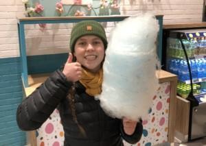 Katariina Räikkönen seisoo sininen hattara kädessä, hymyilee ja näyttää peukaloa.