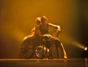 Symbolikuva, jossa on pyörätuolitanssija ja kävelevä tanssija selät vastakkain.