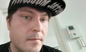 Nuori mies lippalakki päässä.