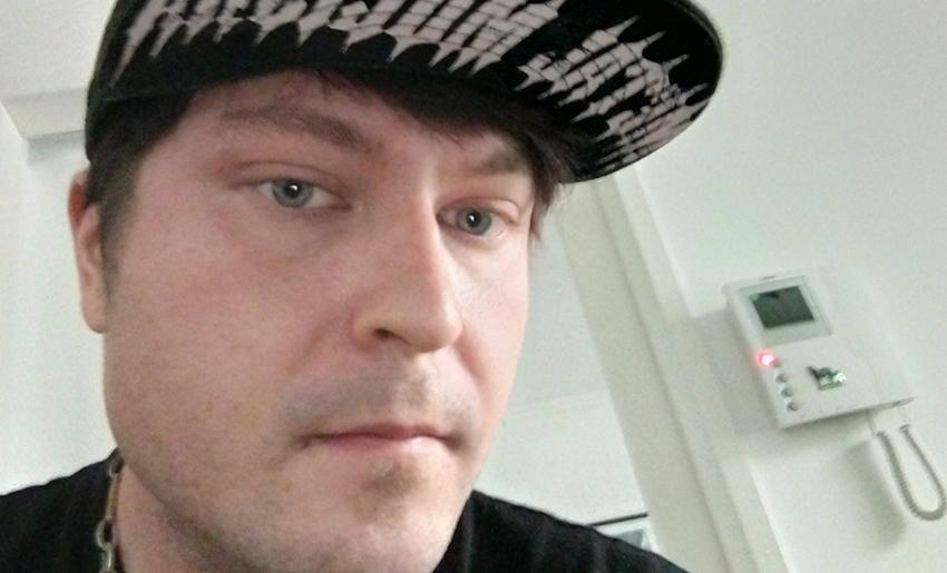 Nuori mies lippalakki päässä.